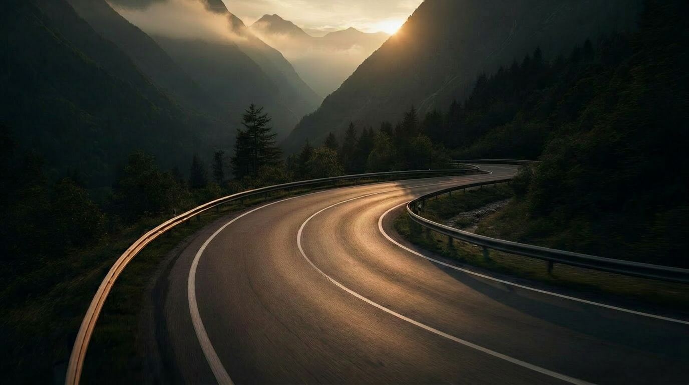 Motorradfahrer in einer Bergkurve im Morgenlicht